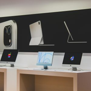 A sleek computer store featuring modern desktop displays and technology advertisements.